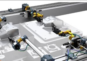 Nahaufnahme einer industriellen Roboter-Montagelinie mit Gelenkarmen und mechanischen Komponenten. Der Aufbau umfasst verschiedene Anschlüsse und Kabel, die auf einem Metallrahmen montiert sind. Das Bild hebt Präzisionsmaschinen und Automatisierungstechnologie hervor.