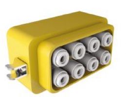 Gelber elektrischer Anschlussstecker mit zwei Metallstiften auf einer Seite und acht runden, in zwei Reihen angeordneten Anschlüssen auf der Vorderseite.